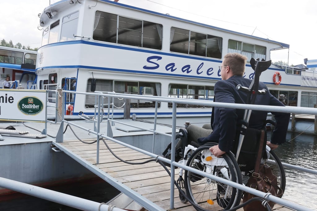 Rollstuhlfahrer Dennis Detschner fährt über einen barrierefreien Steg auf das Fahrgastschiff "Saaleland" auf dem Stausee Hohenwarte.