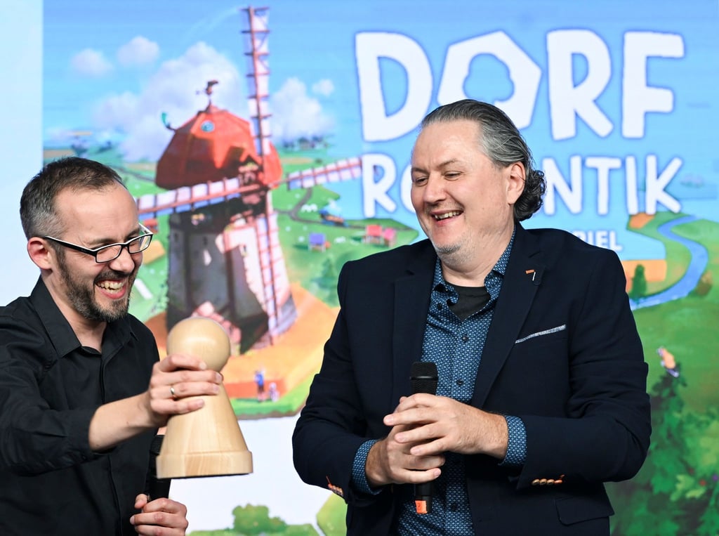 Die Spieleentwickler Lukas Zach (l) und Michael Palm freuen sich über die Wahl ihres Spiels „Dorfromantik: Das Brettspiel“ zum „Spiel des Jahres 2023“.