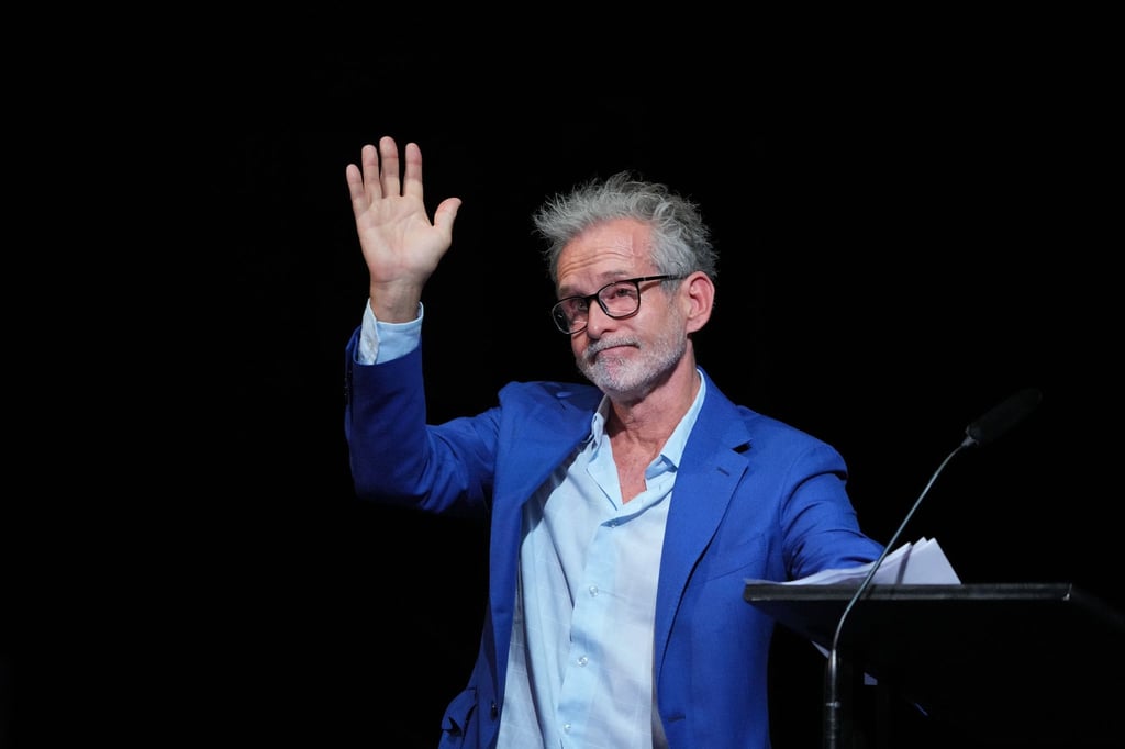 Der Schauspieler Ulrich Matthes winkt.