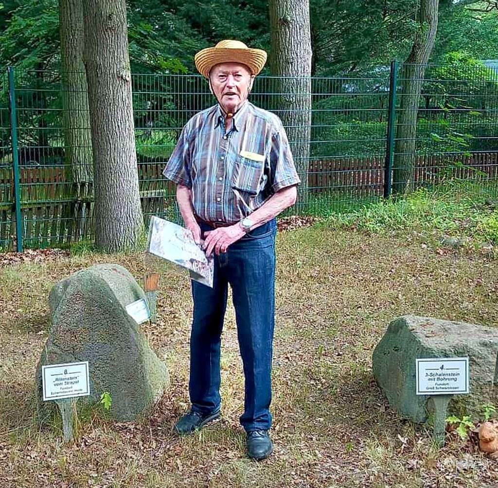 Kurt Hübner erklärt die Bedeutung des „Rillensteins vom Strepel“ (links), der seit 2012 am Blockhaus in Weißewarte steht.