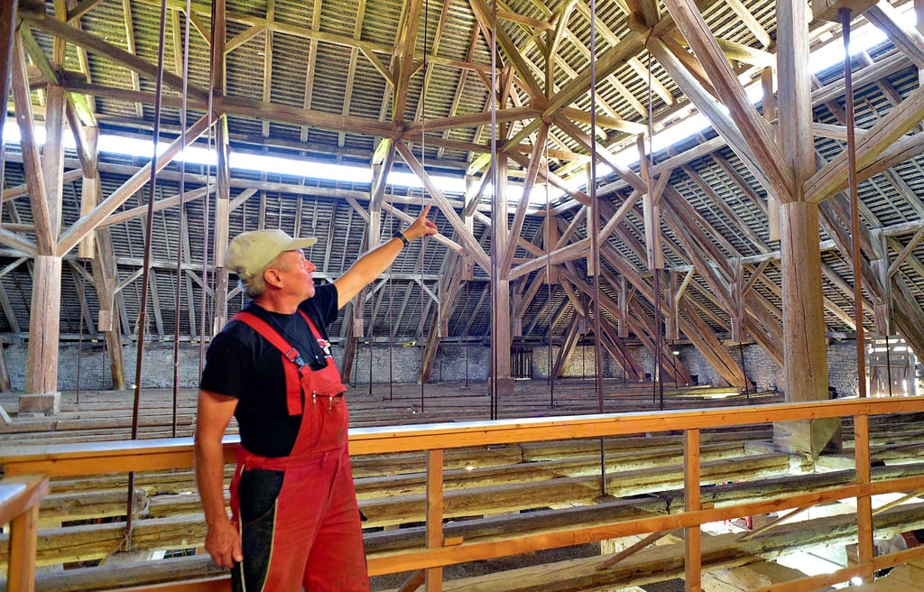 Allein die Dachkonstruktion im Schafstall von Grimschleben ist einen Besuch wert. Burkhard Thiem (Foto) vermutet, dass die großen hölzernen Pylonen, die beim Bau verwendet worden sind, von der eingestürzten Nienburger Schrägseilbrücke stammen.