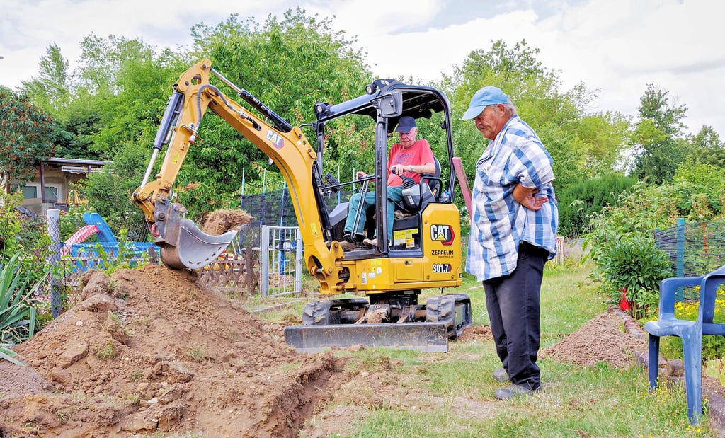 Die Gartenanlage Zeitz- Hainichen saß seit ein paar Jahren auf dem Trockenen. Jetzt wird in Eigenregie eine neue Wasserleitung gebaut. Klaus Seifert fährt den Bagger und Detlef Trampenau nimmt bei Bedarf große Brocken und Steine heraus.