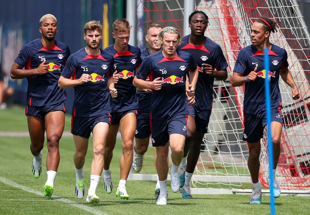 Leipzigs Spieler Benjamin Henrichs (l-r), Timo Werner, Dani Olmo, Xaver Schlager, Emil Forsberg, El Chadaille Bitshiabu und Yussuf Poulsen laufen während einer Trainingseinheit über den Platz.