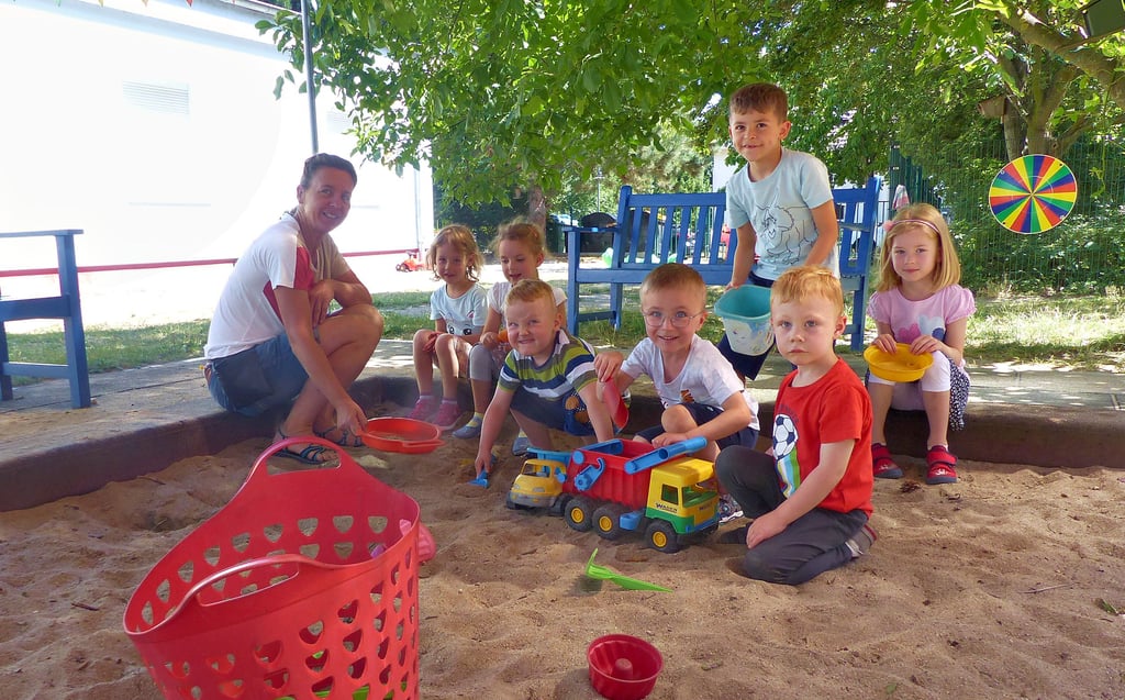 Die Kinder, hier mit Kitaleiterin Sandra Helmecke, freuen sich schon auf die neue Außenanlage, auf der sie hoffentlich bald herumtollen und spielen können.