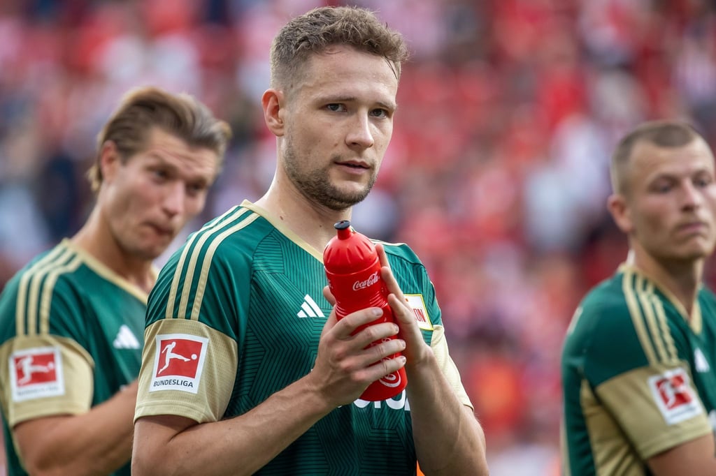 Paul Jaeckel von Union Berlin hält eine Wasserflasche in der Hand.