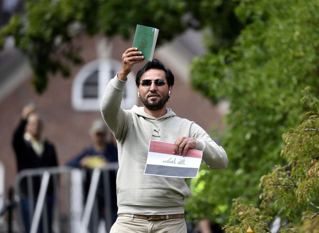 Ein Demonstrant hält eine Kopie des Korans hoch, die er mutmaßlich gemeinsam mit einer irakischen Fahne verbrennen will.
