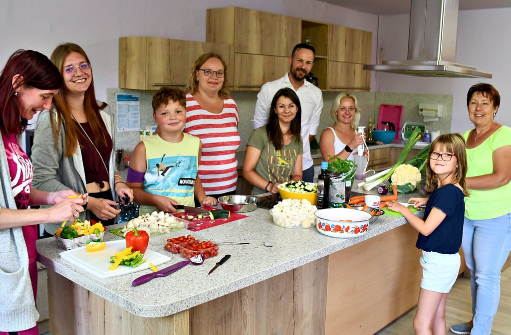 Gemeinsam kochen Mitarbeiter und Gäste in der neuen Küche des Kinderschutzbundes. Hauptsponsor Hardy Ströer schaut ihnen dabei über die Schulter.