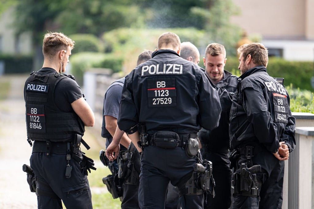 Polizisten koordinieren die Such in einem Wohngebiet in Teltow nach einem Wildtier.
