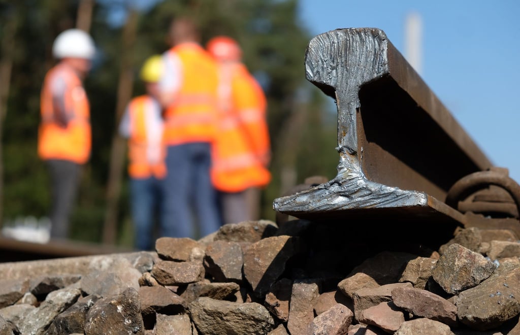 Bauarbeiter stehen auf einer Baustelle am Bahnknoten Dessau-Roßlau.