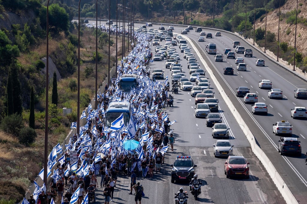 Demonstranten marschieren auf einer Autobahn in Richtung Jerusalem, um gegen die umstrittene Justizreform zu protestieren.