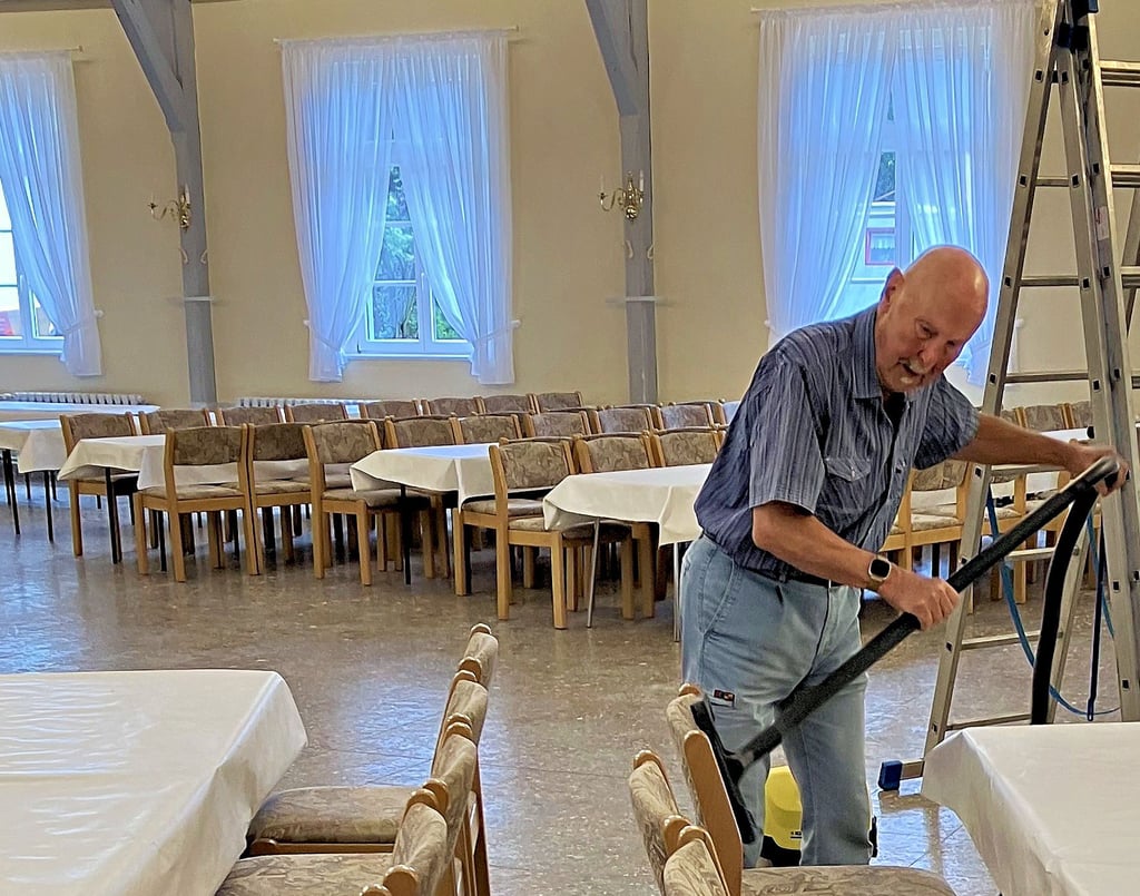 Der 85-jährige Tilo Friedrich gehört zu den ältesten Vereinsmitgliedern. Er befreit die Stühle im Saal vom Staub.