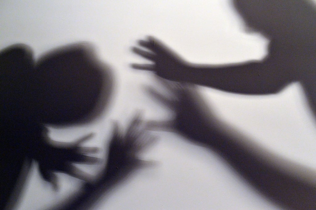 Schatten symbolisieren, wie ein Kind versucht, sich vor der Gewalt eines Erwachsenen zu schützen.