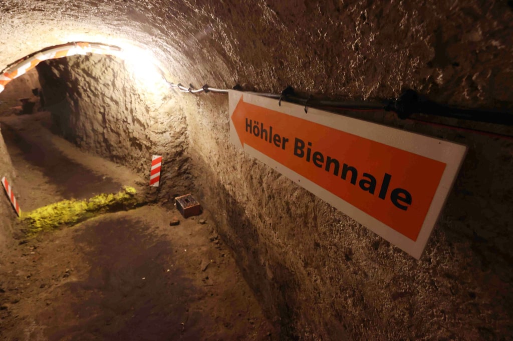 Ein Hinweisschild zeigt zum Eingang der Höhlerbiennale in einem Höhler unter der Stadt.