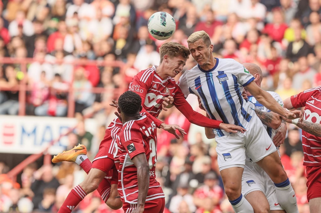 Isaac Price (M) von Standard Lüttich und Marc Oliver Kempf (r) von Hertha BSC kämpfen um den Ball.