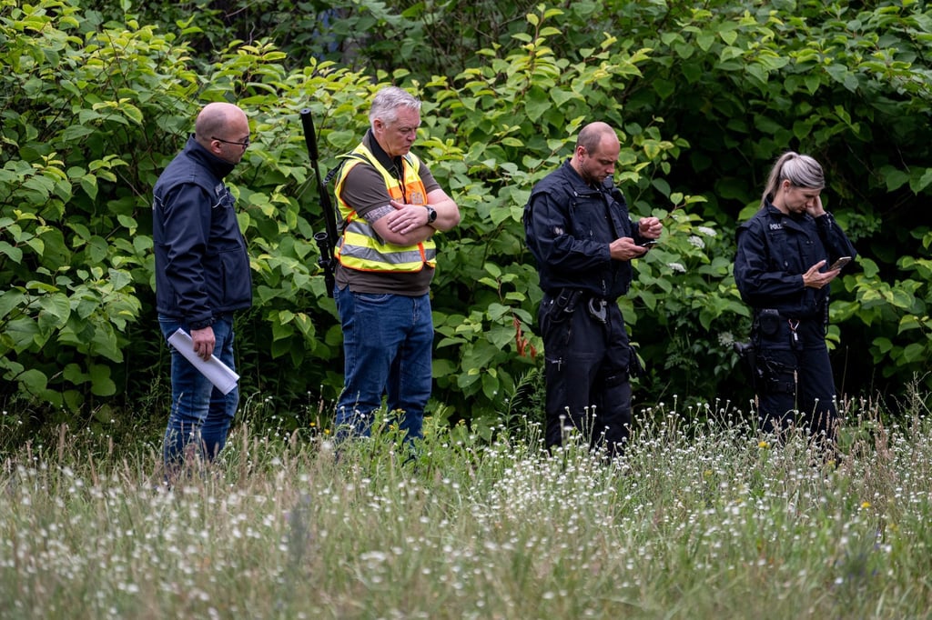 Der Gemeindejäger (2v.l.), ein Mitarbeiter vom Ordnungsamt (l) und Polizisten durchsuchen im Bereich der südlichen Landesgrenze von Berlin den Wald.