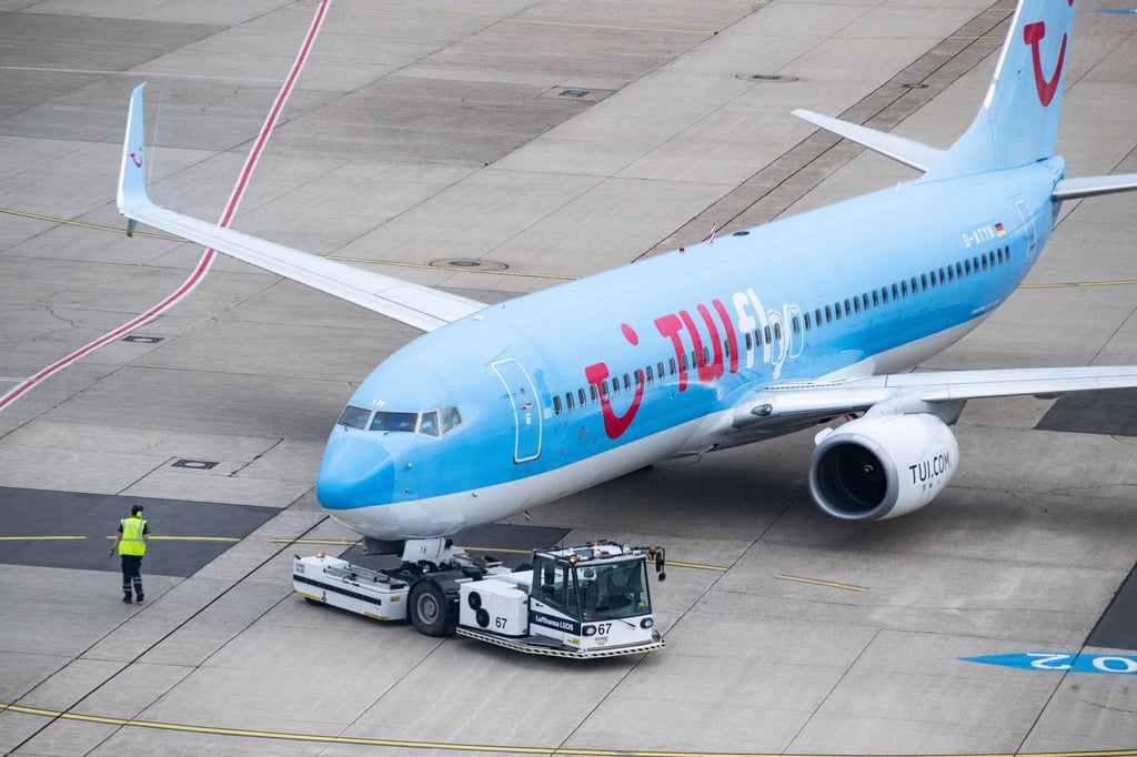 Ein Tui-Flugzeug wird auf dem Vorfeld des Düsseldorfer Flughafens aus der Parkposition geschoben.