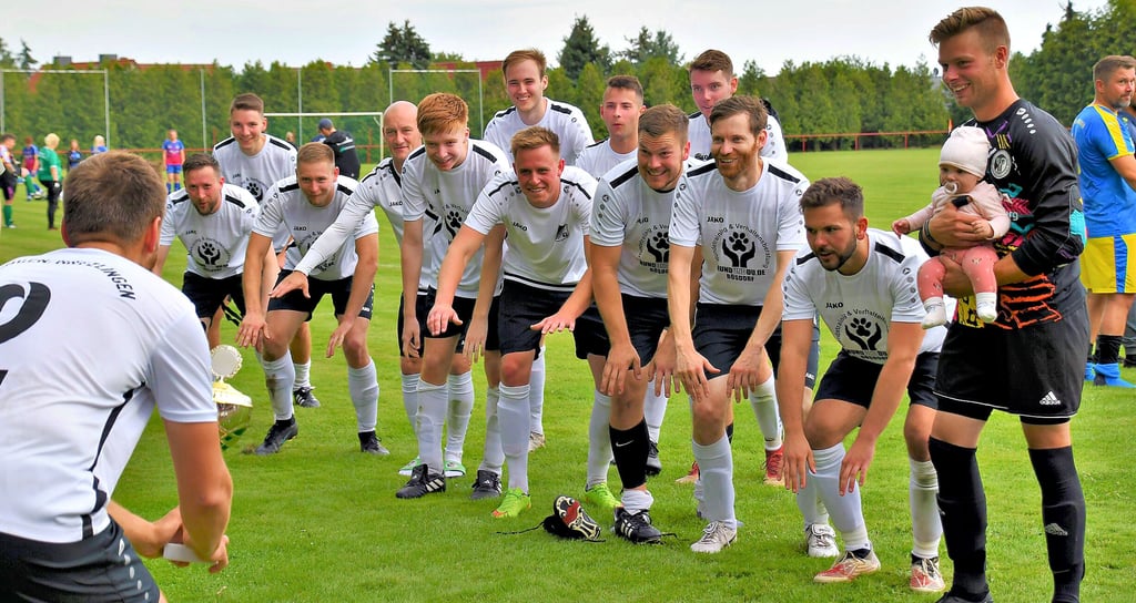 Da ist der Pott: Der Kapitän des SV Etingen/Rätzlingen geht mit dem Sieger-Pokal auf sein Team zu, dass ihn schon mit einer Welle erwartet. Ines Jachmann