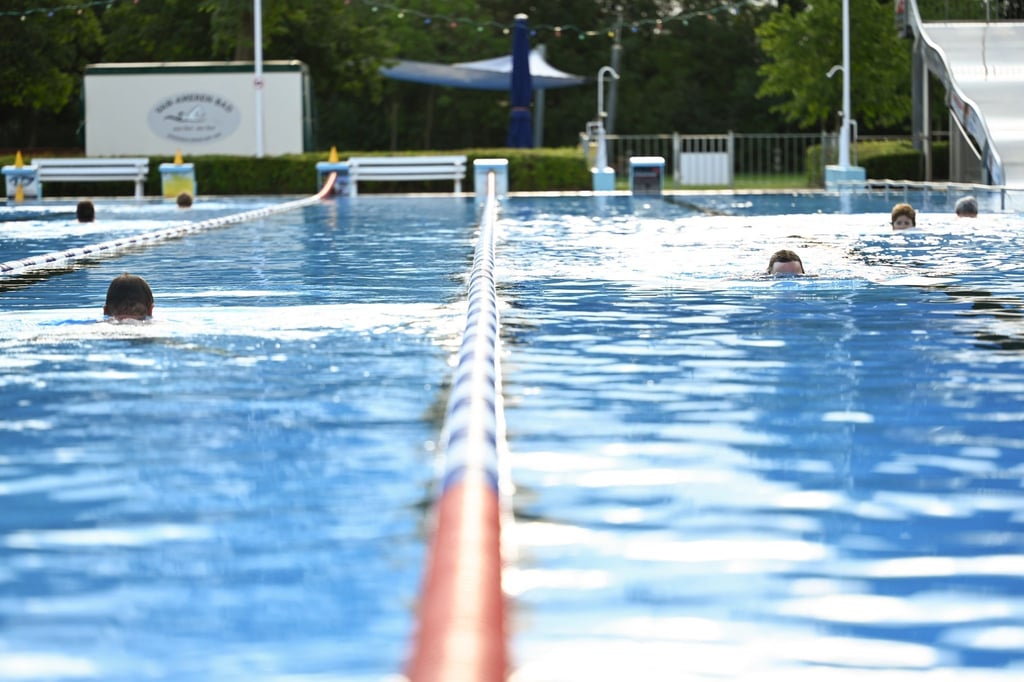 Badegäste genießen das morgige Schwimmen im Freibad.