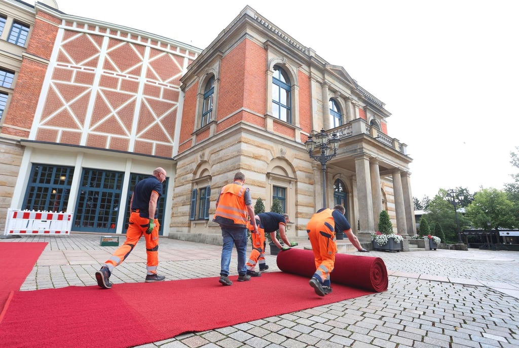 Der rote Teppich wird vor dem Bayreuther Festspielhaus ausgerollt.