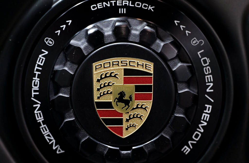 Das Porsche-Logo ist auf der Felge eines Fahrzeugs zu sehen.