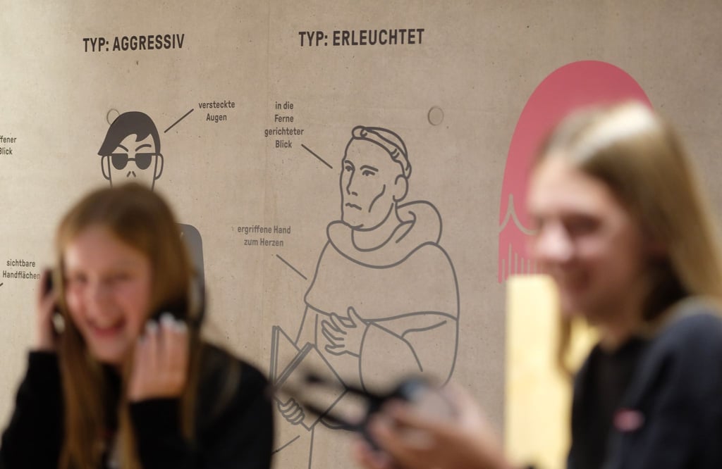 Schülerinnen hören Beiträge der Ausstellung „Raus mit der Sprache“ in Luthers Sterbehaus.