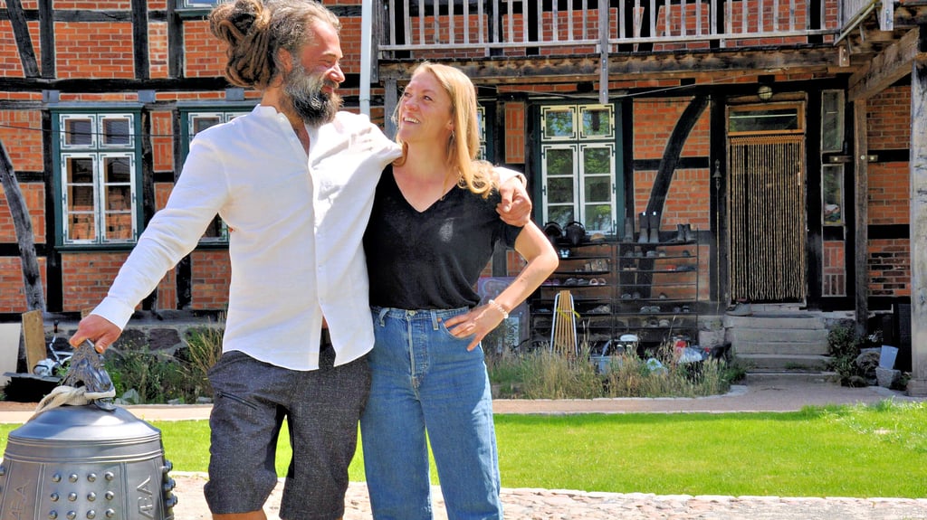 Christian Laase und Jana Kusick im Innenhof ihres mit viel Liebe zum Detail aufgebauten „Seminarhofs Astraea“. Als Zeichen für die Entschleunigung, die ihre Gäste und auch sie selbst dort erleben sollen, haben sie eine Tempelglocke aufstellen lassen.