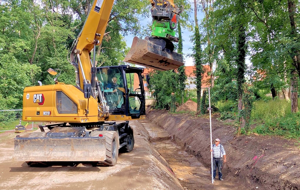 Mitarbeiter der Bernburger Firma HTB heben die Baugrube zwischen Kurhaus-Parkplatz und Kurgarten aus, wo eine Hochwasserschutzmauer mit gläsernen Sichtelementen installiert wird.
