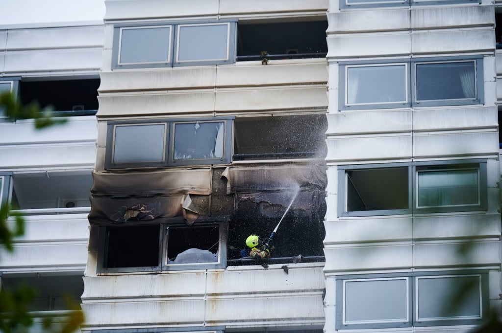 Ein Feuerwehrmann löscht einen Brand in einem Hochhaus.