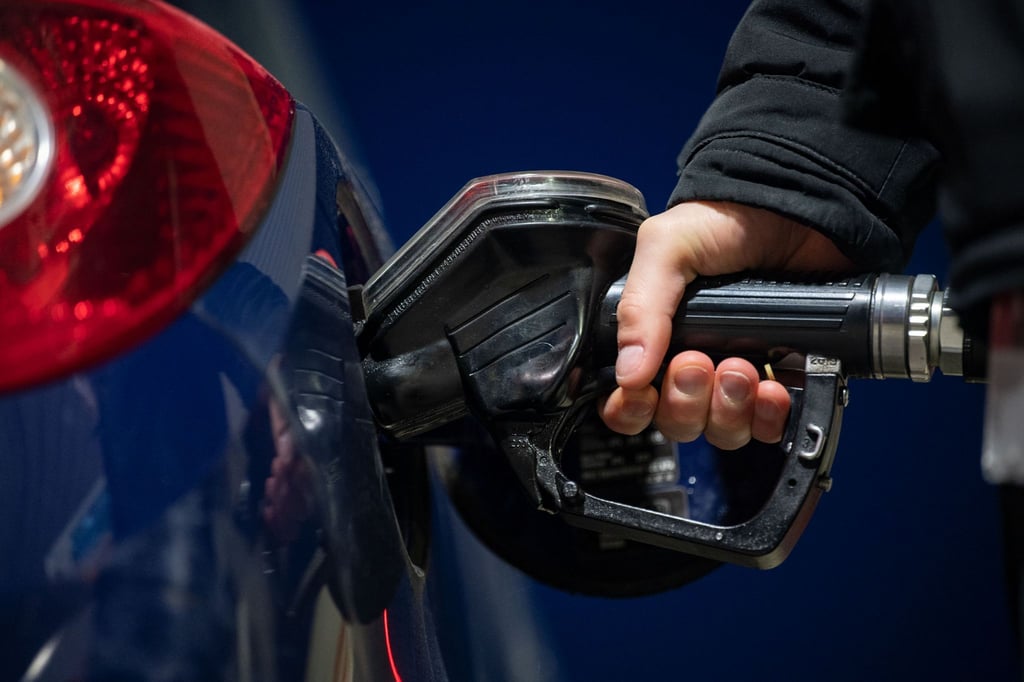 Ein Mann tankt seinen Wagen an einer Tankstelle.
