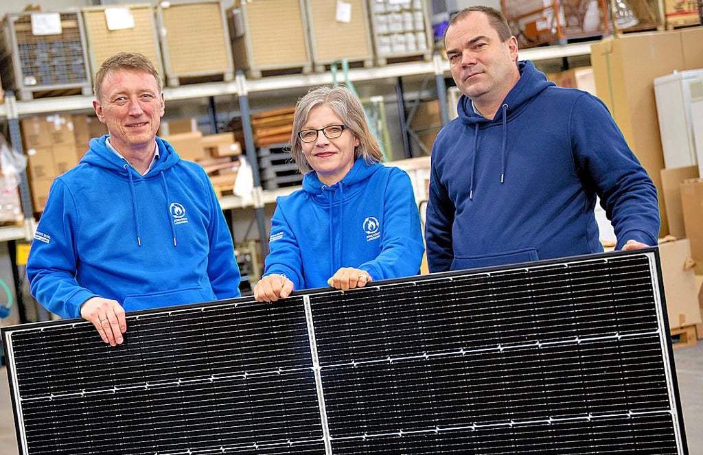 Swen Löppen, Annette Meyer (Stadtwerke) sowie Mathias Holzberger (Energienetze) an einer Photovoltaikanlage.