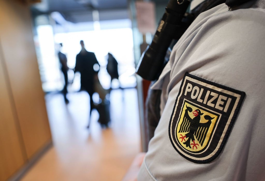 Ein Beamter der Bundespolizei kontrolliert Reisende am Flughafen.
