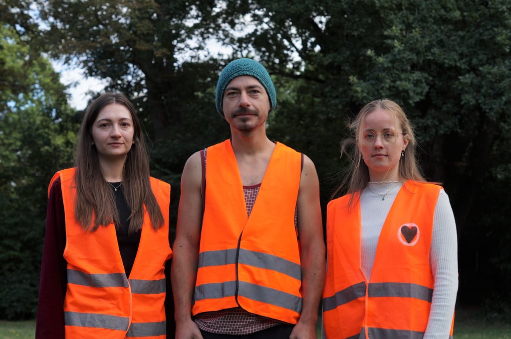 Aktivisten der Letzten Generation Halle in ihren markanten Warnwesten: Emma, Stephan und Anni (von links).