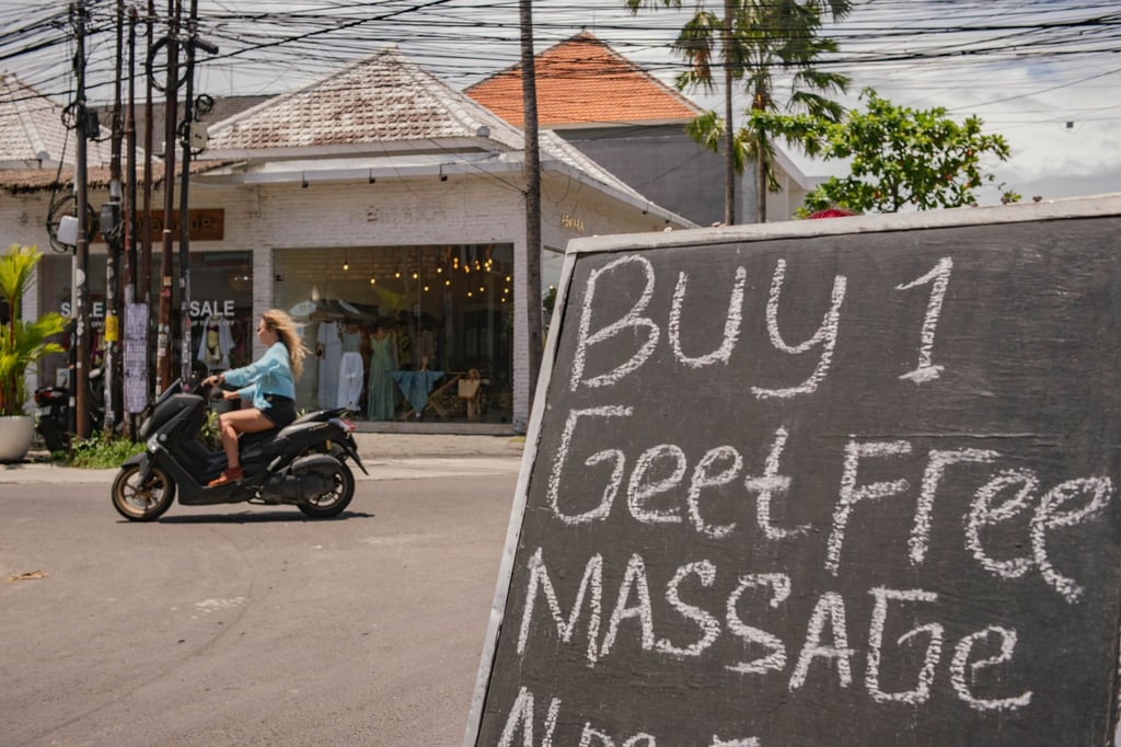 Eine Frau fährt ohne Helm auf einem Motorroller. Wegen zahlreicher Verstöße gehen indonesische Behörden inzwischen hart gegen Verkehrsverstöße vor.