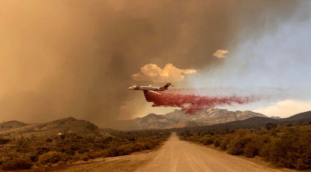 Ein Löschflugzeug ist über dem Mojave National Preserve im Einsatz, einem Schutzgebiet im US-Bundesstaat Kalifornien.