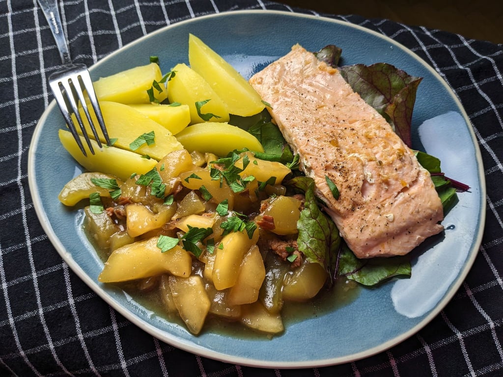 Zu den Schmorgurken mit Zwiebeln und Schinkenwürfeln passen Salzkartoffeln und Lachs.