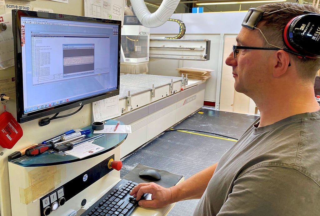 Bevor es auf die große Fräse im Hintergrund geht, wird die Skizze am Computer von Maik Pfeiffer auf Fehler überprüft.