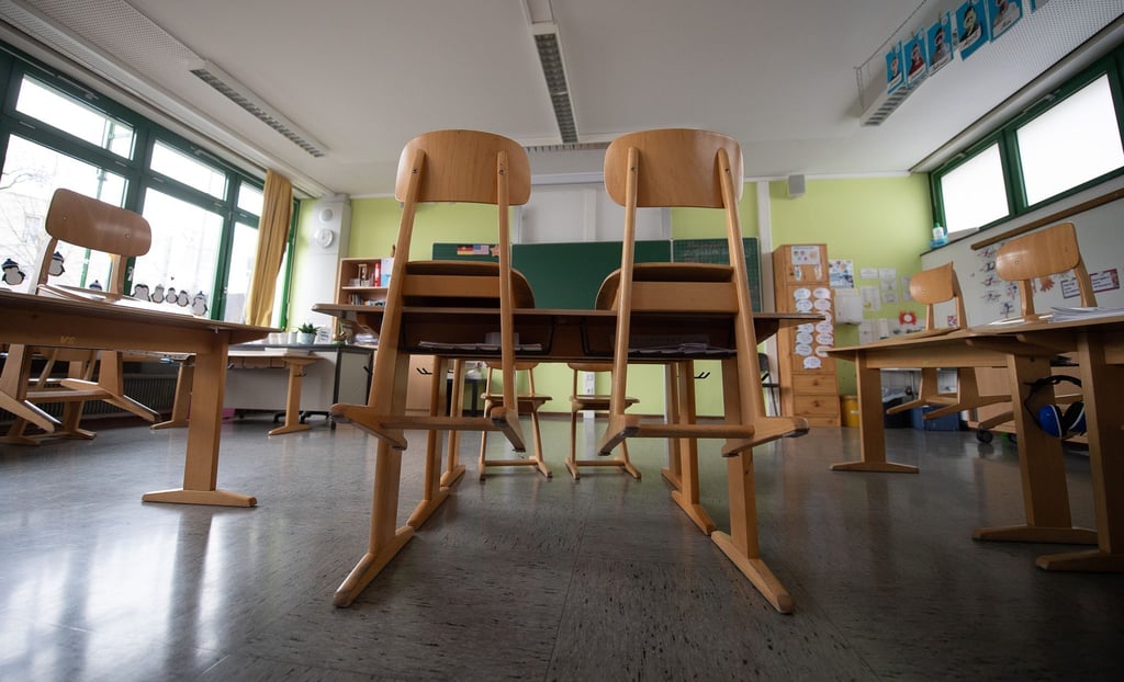 Die Stühle stehen in einem Klassenzimmer einer Grundschule auf den Tischen.