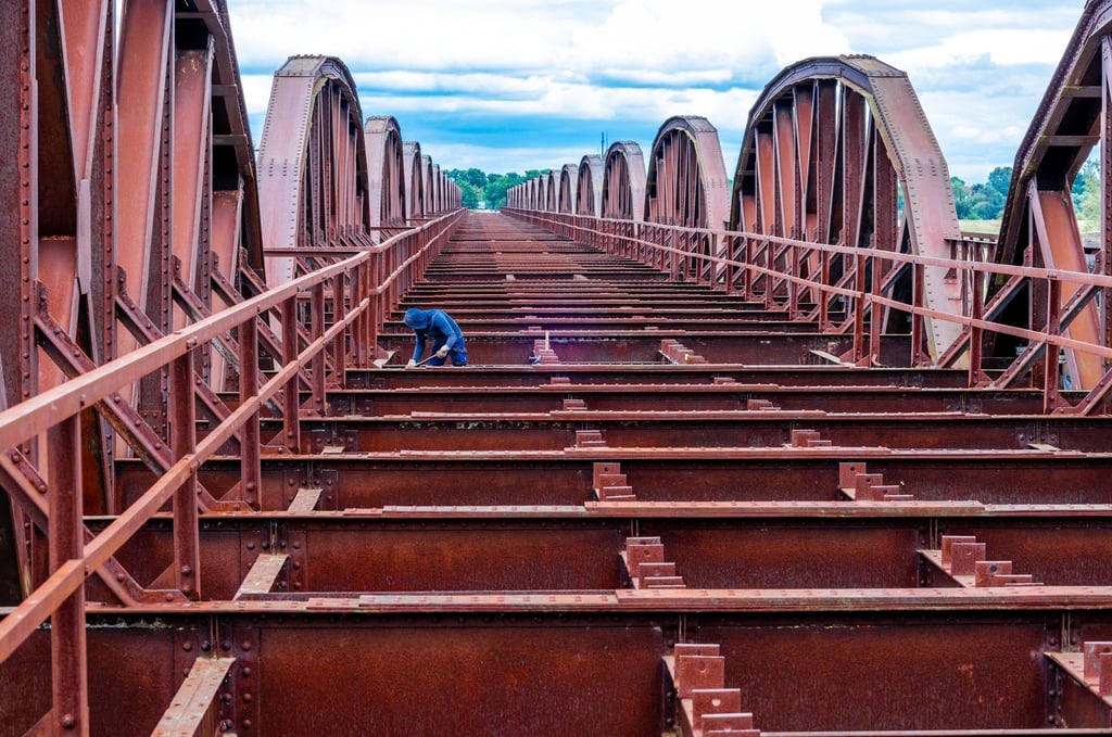 Ein Arbeiter schleift an den Stahlteilen auf dem ehemaligen Dömitzer Eisenbahnbrücke an der Elbe.