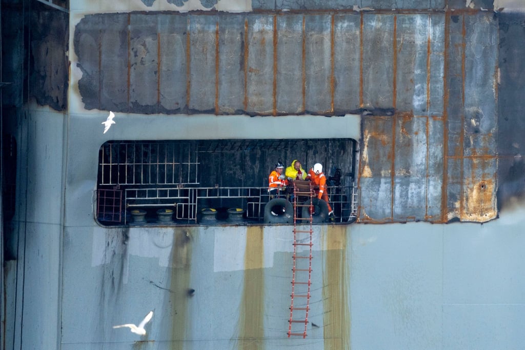 Sicher im Hafen: Arbeiter an Bord des schwer beschädigten Autofrachters „Fremantle Highway“.