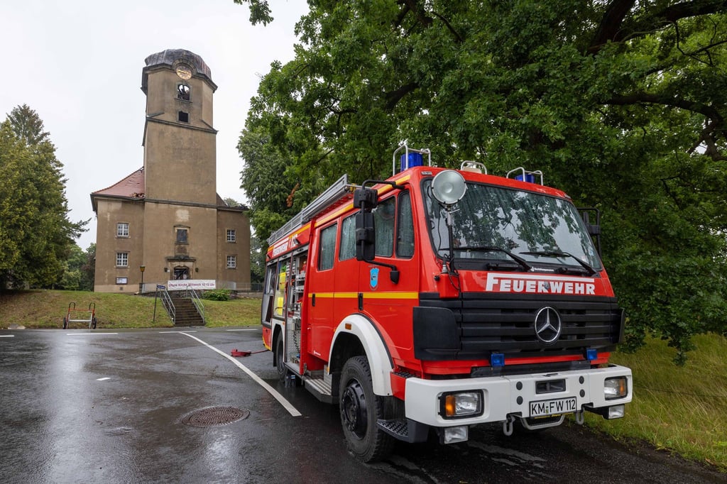 Ein Fahrzeuge der Feuerwehr ist vor der Stadtkirche Großröhrsdorf zu sehen.
