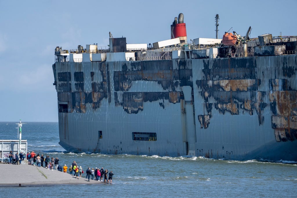 Der Autofrachter „Fremantle Highway“ wird an Schaulustigen vorbei in den Hafen gezogen.