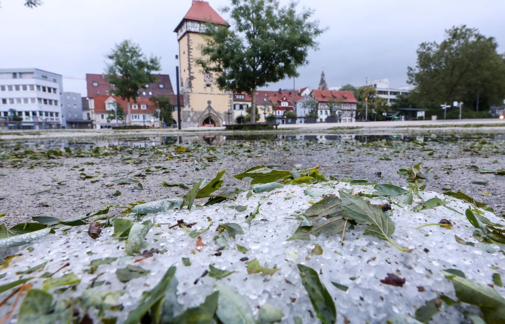 Hagelkörner und vom Sturm abgerissene Blätter liegen in Reutlingen auf dem Boden.