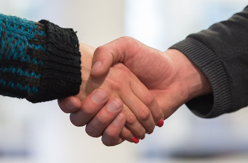 Ein Mann und eine Frau begrüßen sich mit Handschlag.