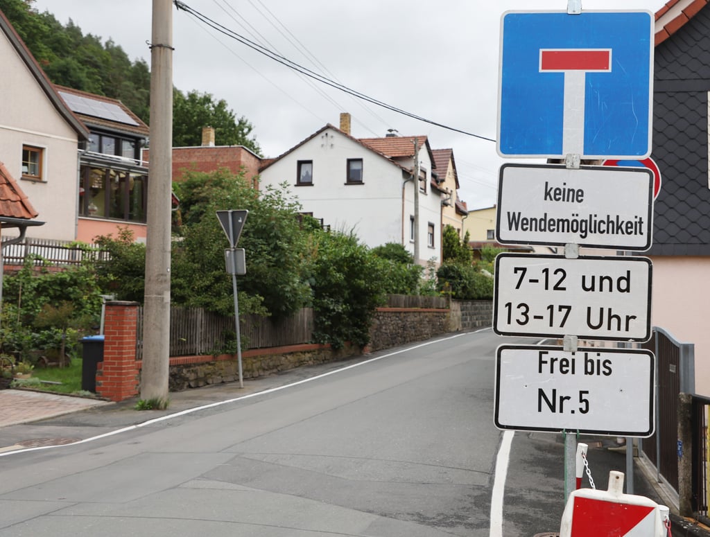 Verkehrszeichen zeigen die Sperrung der Dorfstraße an. Eine Baustelle im Dorf Kleindembach schneidet den Ort Langendembach tagsüber von der Außenwelt ab. Nur in der Mittagszeit können Fahrzeuge für eine Stunde die Baustelle passieren.