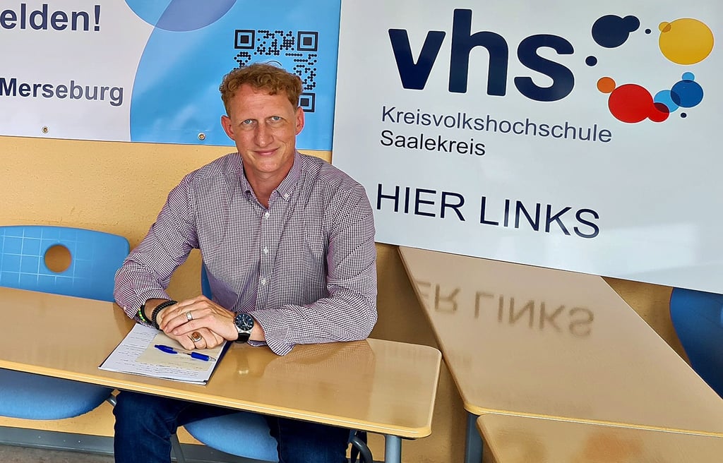 Schulleiter Stefan Schmidt vor einem Teil der neuen Werbebanner der Kreisvolkshochschule.