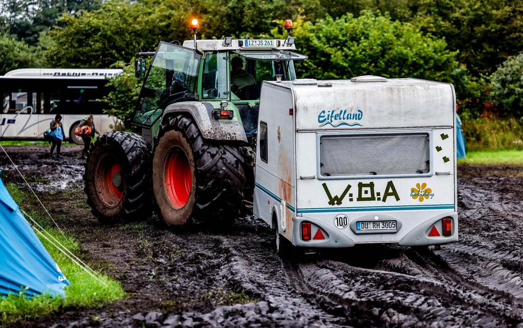 Ab durch den Schlamm: Ein Traktor zieht einen Wohnwagen vom Campinggelände des Wacken Open Air.