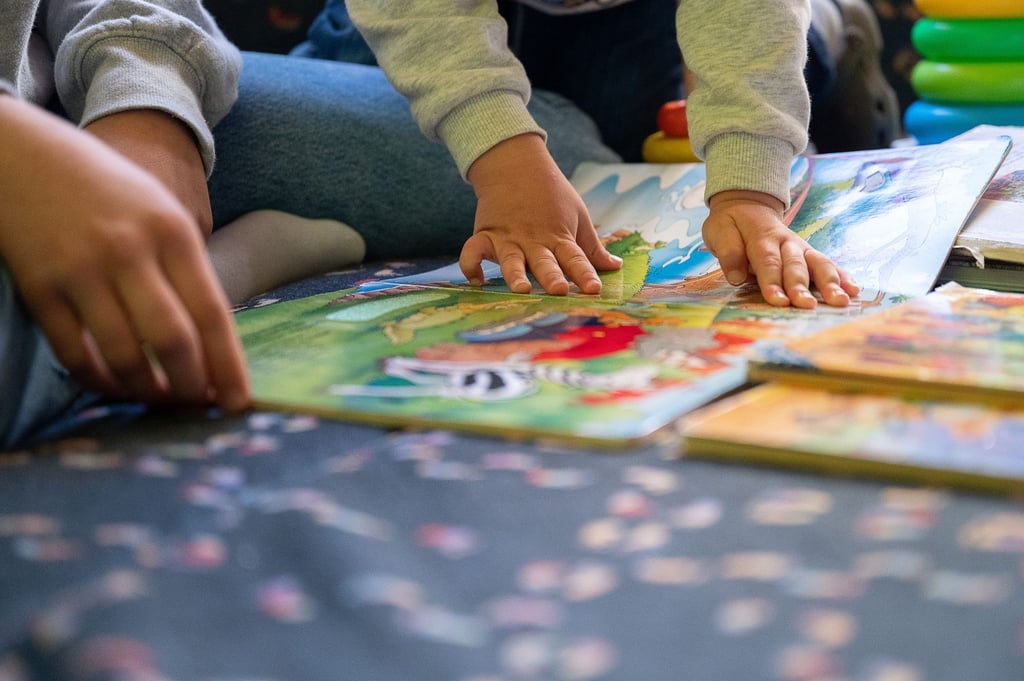 Eine Praktikantin liest in einer Kita Kindern vor.
