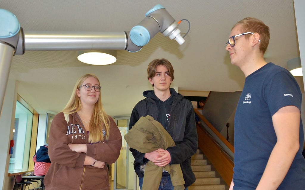 Alexander Ziege (rechts) zeigt den beiden Schülern Finja Bendix und Lucas Meinicke einen Roboterarm, der bei der Thyssenkrupp Pesta  Schönebeck zum Einsatz kommt. 