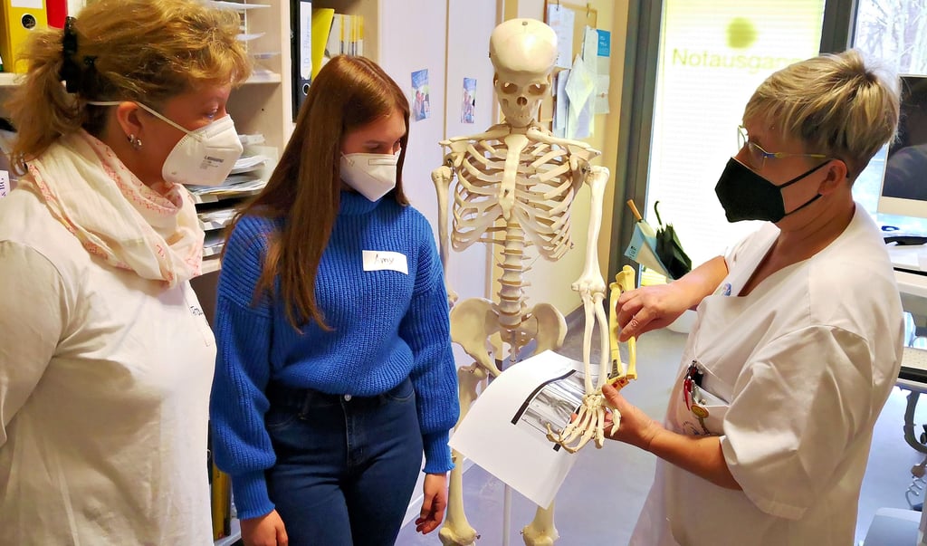 Die stellvertretende Stationsschwester Kerstin Schmidt (r.) erklärt Jana Kühn (l.) und Amy Sachtleben die Behandlung einer Radisfraktur.