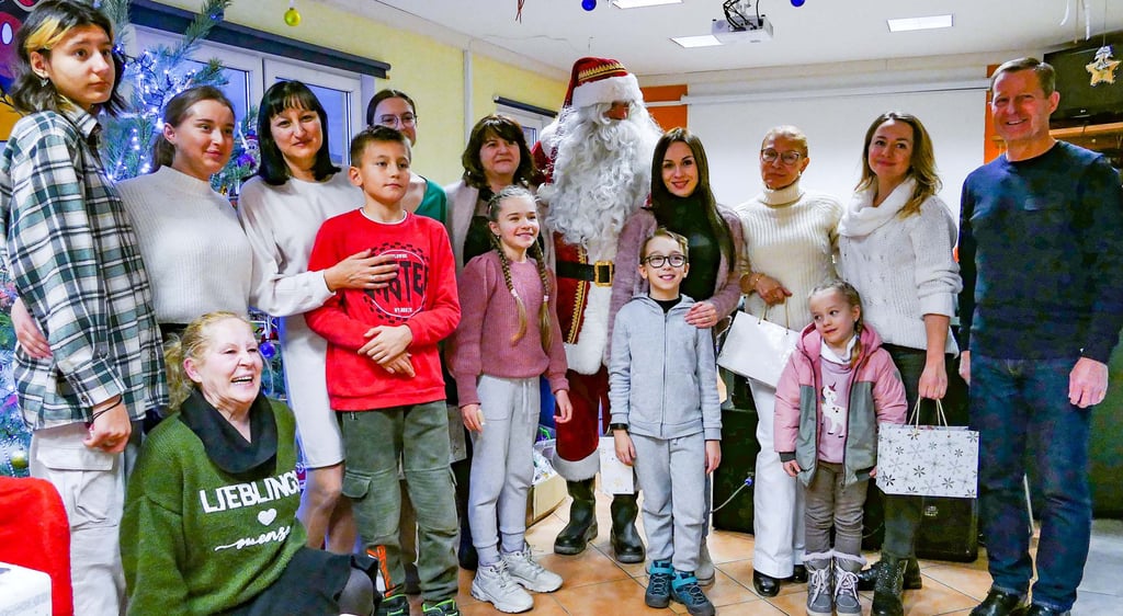 Ukrainische Flüchtlinge feiern im Elsteraner Jugendclub Weihnachten weit weg von der Heimat. Geschenke hat nicht nur der Weihnachtsmann übergeben, sondern auch Bürgermeister von Zahna-Elster Peter Müller (rechts), der sich freut, dass diese mit Spenden finanziert werden konnten.
